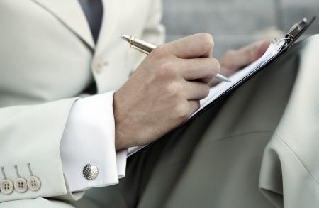 man writing on clipboard