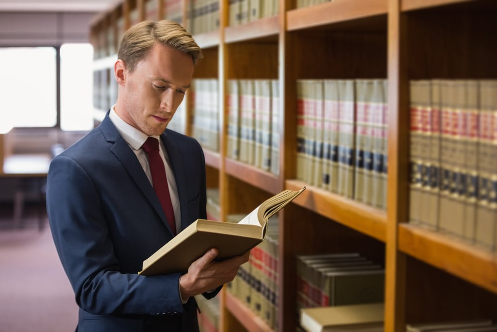 Lawyer in library reading a book