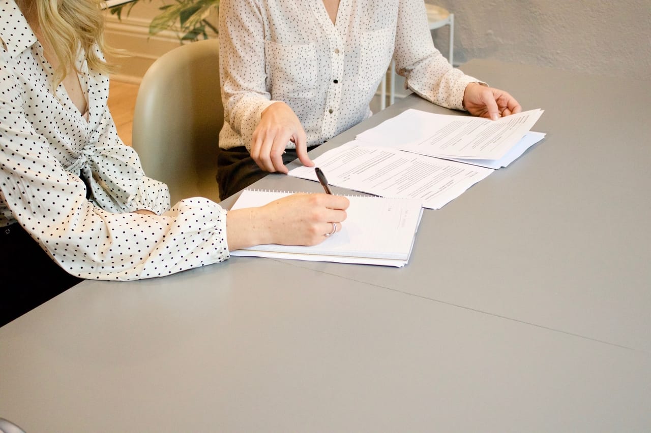 two women signing documents