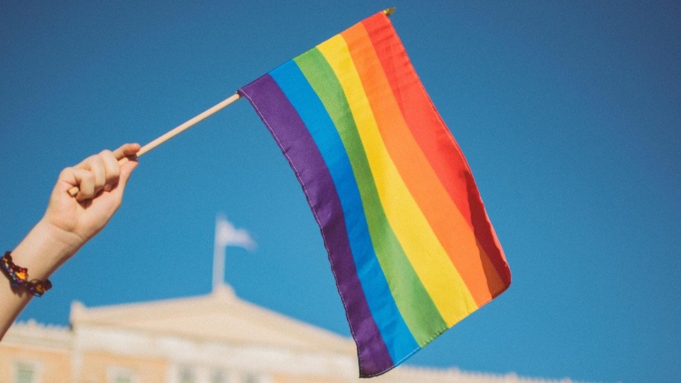 person waving a pride flag