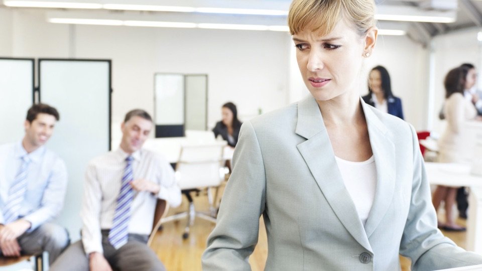 uncomfortable woman after inappropriate comments from male coworkers