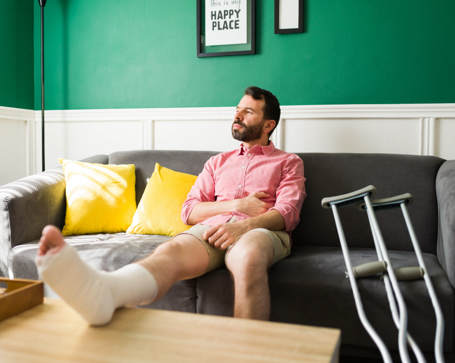 man on couch with cast and crutches